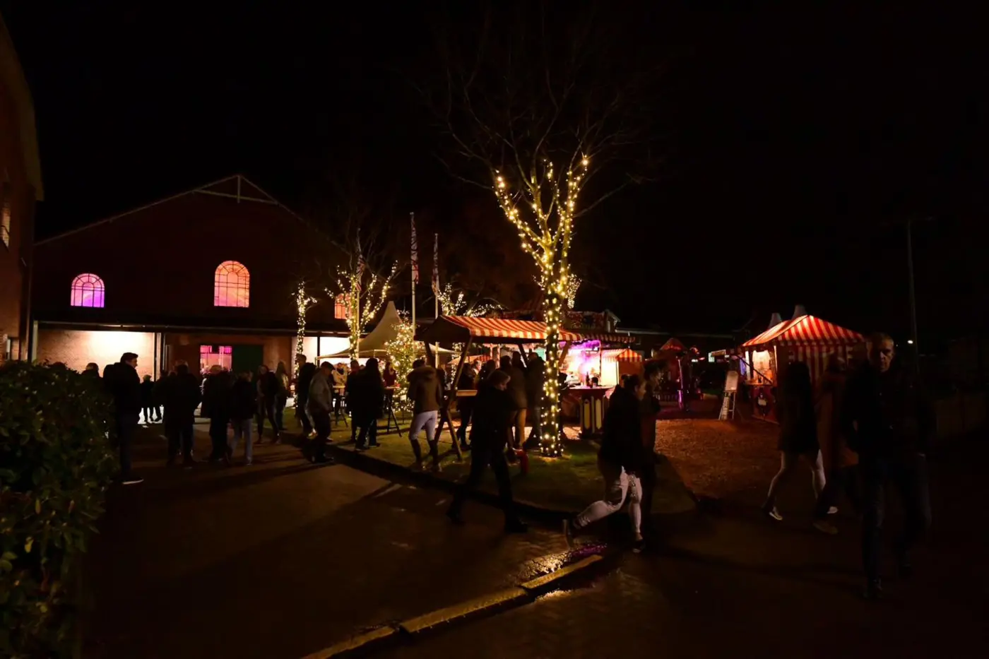 Weihnachtsmarkt mit beleuchteten Buden vor der historischen Reithalle in Elmshorn